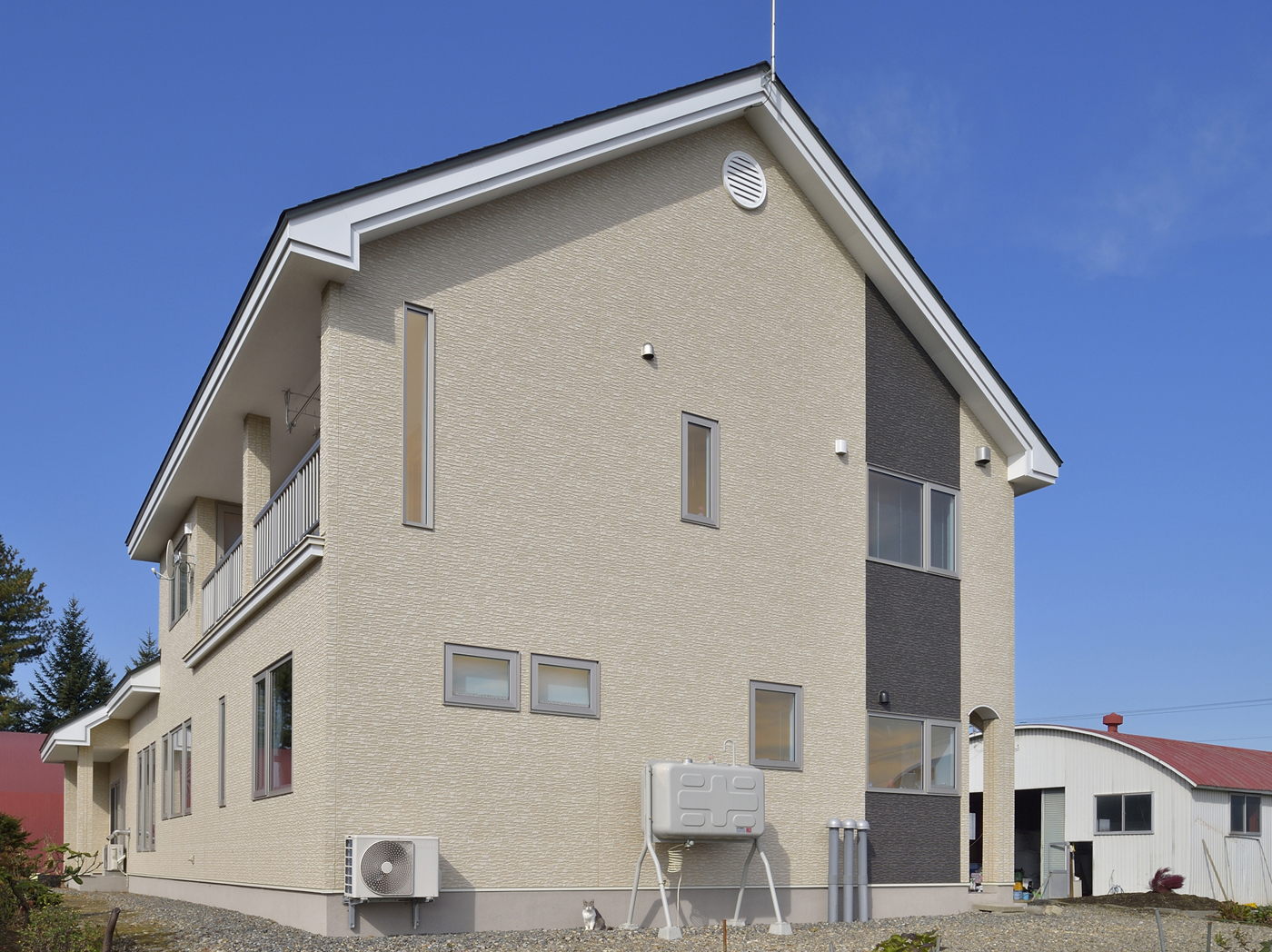 ベージュの外壁にグレーのラインが入った住宅