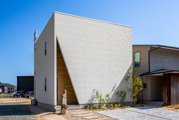 玄関を三角に切り抜いたグレー外壁の住宅