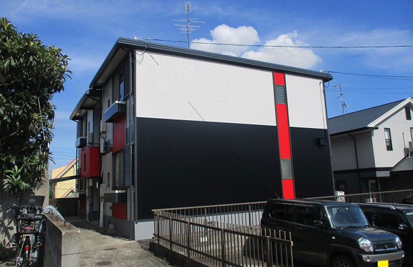 モノトーンに赤のワンポイントが入った住宅外壁